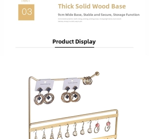 Close-up of golden iron earring stand with multi-tier hooks and natural wooden base