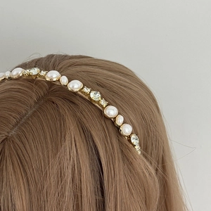 Eleganter goldener Metallhaarreif mit Perlen und Kristallen in der 45-Grad-Seitenansicht