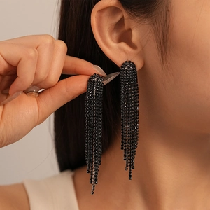 Close-up of elegant long black rhinestone tassel earrings worn on ear for women
