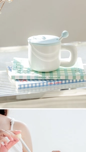 Detail of minimalist ceramic mug set with chunky handle, blue lid, and stirring spoon