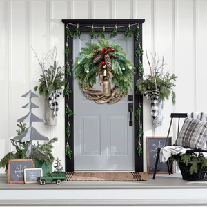 Detailed view of Christmas wreath with pine needles, cones, berries and rustic metal bells