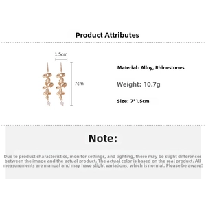 Detail view of gold flower drop earrings with pearls and rhinestones measuring 7cm by 1.5cm