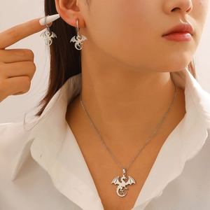 Silver dragon jewelry set with hollow pendant necklace and matching earrings on model
