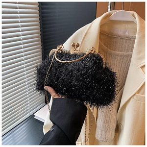 Détail du sac coquille en fausse fourrure noire avec poignée et chaîne dorées