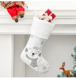 Dettaglio calza di Natale in tessuto bianco con orso ricamato e risvolto in peluche