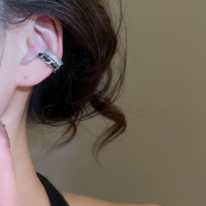 Detailed view of a silver double-row ear cuff with black and white zircon stones