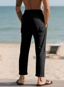 Dettaglio dei pantaloni casual neri da uomo con vita elastica e tasca posteriore al mare