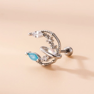 Macro shot of silver crescent moon and blue zircon flower earring with ball backing