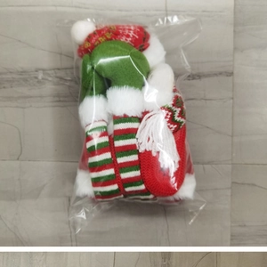 Detail of Christmas knitted hat and striped sock set in clear plastic packaging
