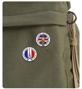 Detailed view of metal enamel badges featuring London Big Ben and Paris Eiffel Tower