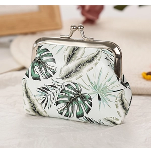 Close-up of a coin purse with tropical palm leaf print and silver metal clasp closure