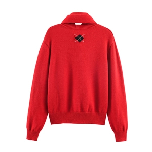 Detail of red turtleneck sweater featuring a classic argyle pattern on the back collar
