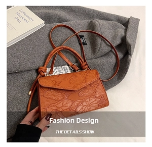 Détail du sac en cuir gaufré orange-brun avec motifs de lotus et poignée élégante
