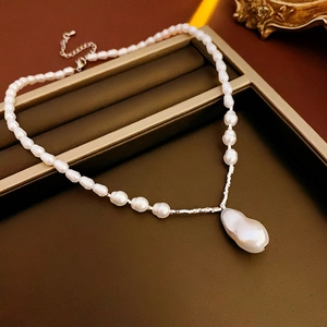 Detail of baroque pearl pendant necklace with vintage silver chain and freshwater pearls