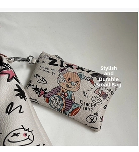 Détail d'une mini pochette crème avec imprimé graffiti ours et crochet métallique pratique