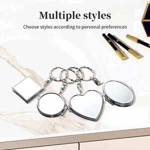 Detail showing four different foldable metal mirror keychains in heart and oval shapes