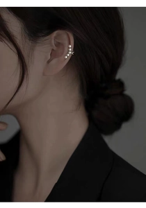 Close-up of a silver pearl ear cuff worn by a model showcasing the five-pearl curved design