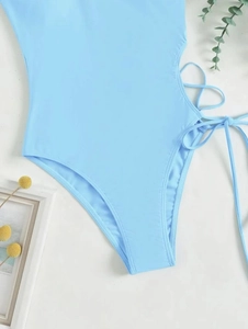 Detail of sky blue one-piece swimsuit featuring side drawstring ties and high-cut leg