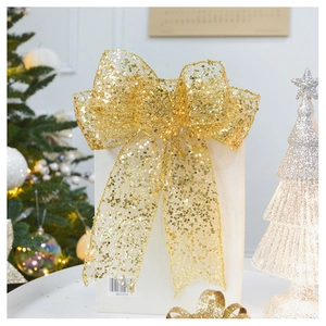 Detail of glittery champagne gold sequin bow ornament on a white gift bag display