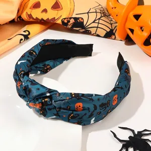 Detail view of Halloween knot headband featuring orange pumpkins and bats on dark fabric