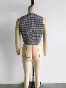 Vue détaillée du dos d'un gilet pied-de-poule noir et blanc sur un mannequin de couture