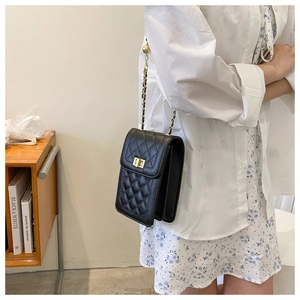 Close-up of black quilted cell phone bag with gold chain strap and metal swivel lock