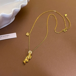 Makro-Detail eines 24k Gold Koi Fisch Anhängers mit weißem Zirkon und Kleeblatt