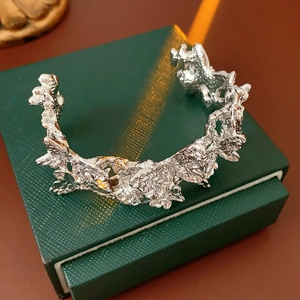 Détail du bracelet ouvert argenté avec texture de métal liquide irrégulier sur boîte