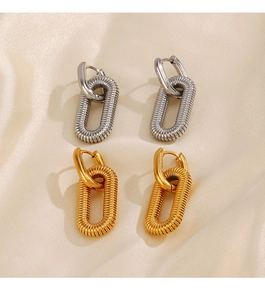 Detail of 18K gold and silver geometric oval hoop earrings with spiral texture on silk