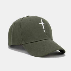 Detail view of olive green cotton baseball cap with white cross embroidery and twill texture