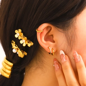 Boucles d'oreilles créoles dorées en acier inoxydable avec zircone sur un mannequin