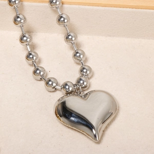 Polished silver heart pendant necklace with chunky round bead chain on a minimalist base