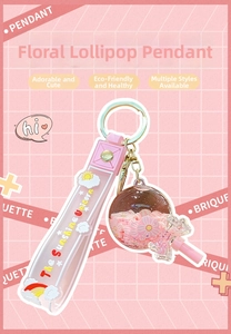 Detailed view of pink flower lollipop keychain with sunshine unicorn strap and golden ring