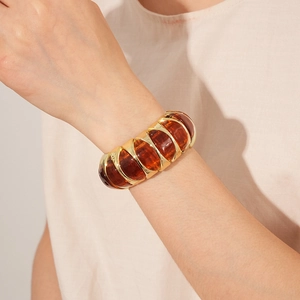 Close-up of retro amber resin and gold metal link stretch bracelet on a model wrist