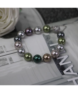 Détail d'un bracelet de perles multicolores avec fermoir magnétique en cristal et chaîne