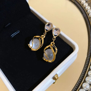 Détails des boucles d'oreilles goutte en œil de chat sur du velours noir