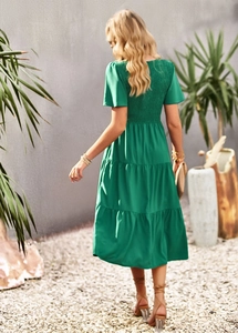 Detail of smocked bodice and tiered ruffle skirt on a green A-line summer dress from back