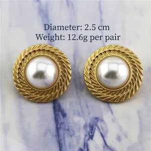 Détail de boucles d'oreilles perles dorées de 2,5 cm avec bordure à motif épi