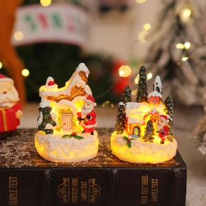 Detail of glowing LED resin Christmas miniature houses with snow and Santa on vintage books