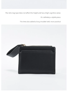 Detail view of black cross-grain leather wallet with metallic zipper and handle