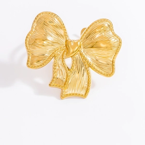 Detailed view of golden bow ring with textured wings and intricate metal craftsmanship