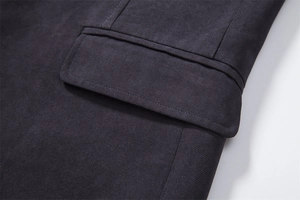 Close-up detail showing the diagonal twill fabric texture and pocket stitching of the coat