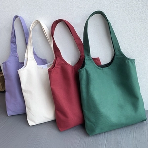Row of colorful canvas tote bags in purple, cream, wine red, and dark green colors