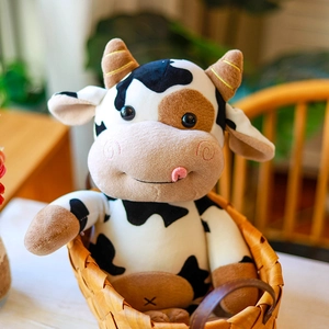 Lindo peluche de vaca blanco y negro sentado en una cesta de mimbre rústica para decoración
