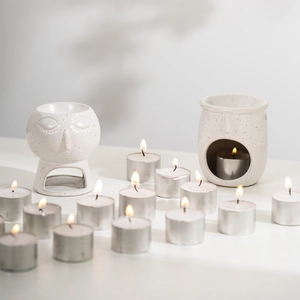 Abstract white ceramic essential oil burners with tea light candles and plant shadows