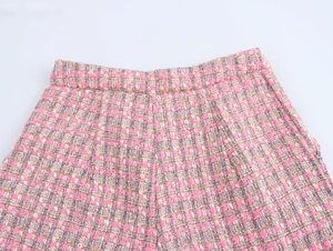 Gros plan sur la texture du tissu en tweed rose et blanc d'un pantalon décontracté pour femme