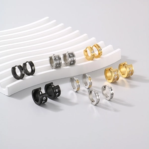 Macro view of C-shaped titanium steel hoop earrings with cubic zirconia in assorted colors
