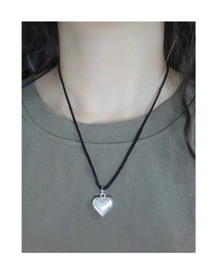 Close-up of S925 silver heart pendant on a black adjustable cord necklace worn by a model