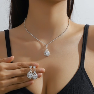 Elegant silver pear-cut rhinestone necklace and drop earrings set worn by a model