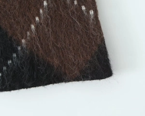 Close-up of the fuzzy plaid knit fabric showing dark brown and black diamond patterns
